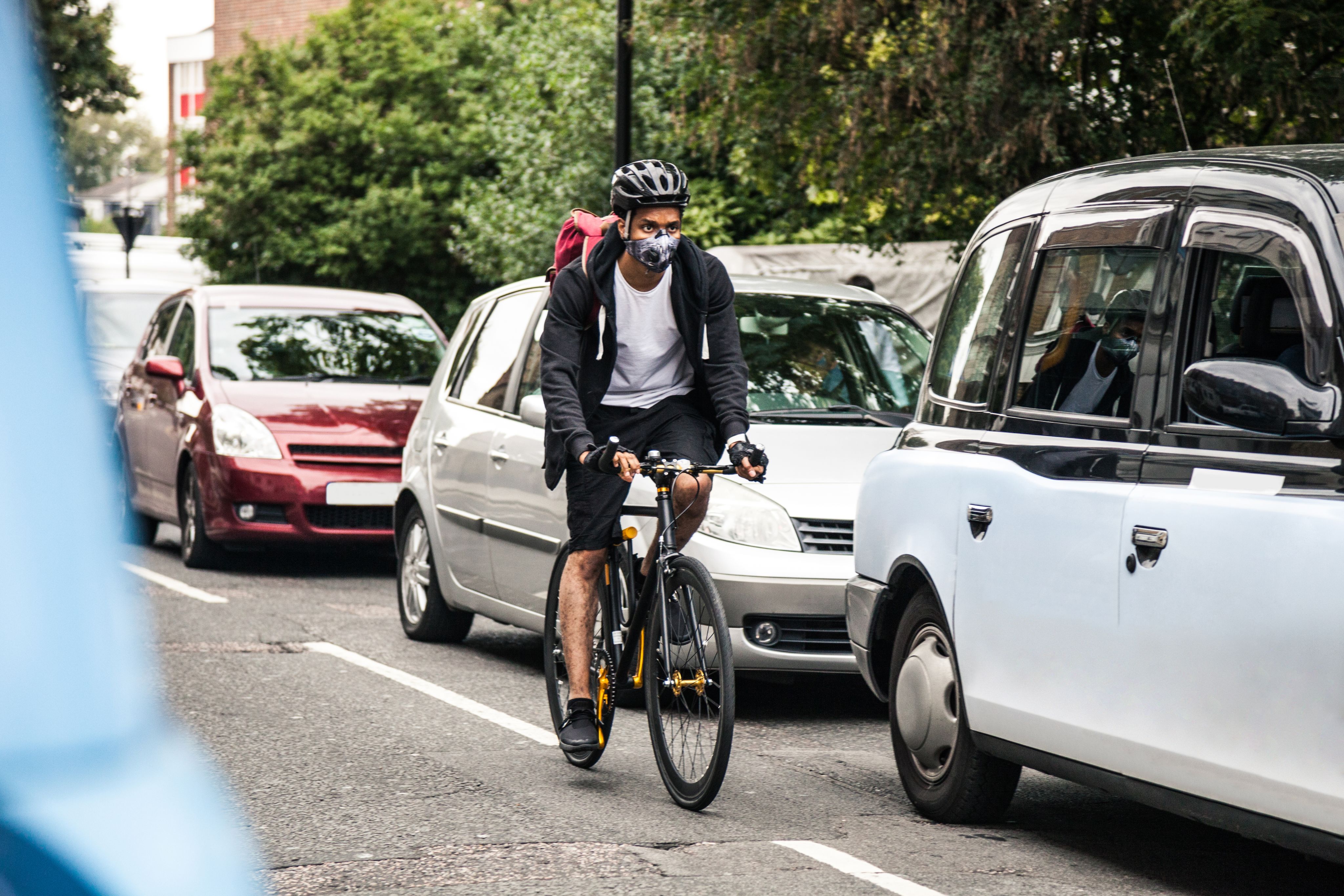 Male cyclist with face mask riding in traffic