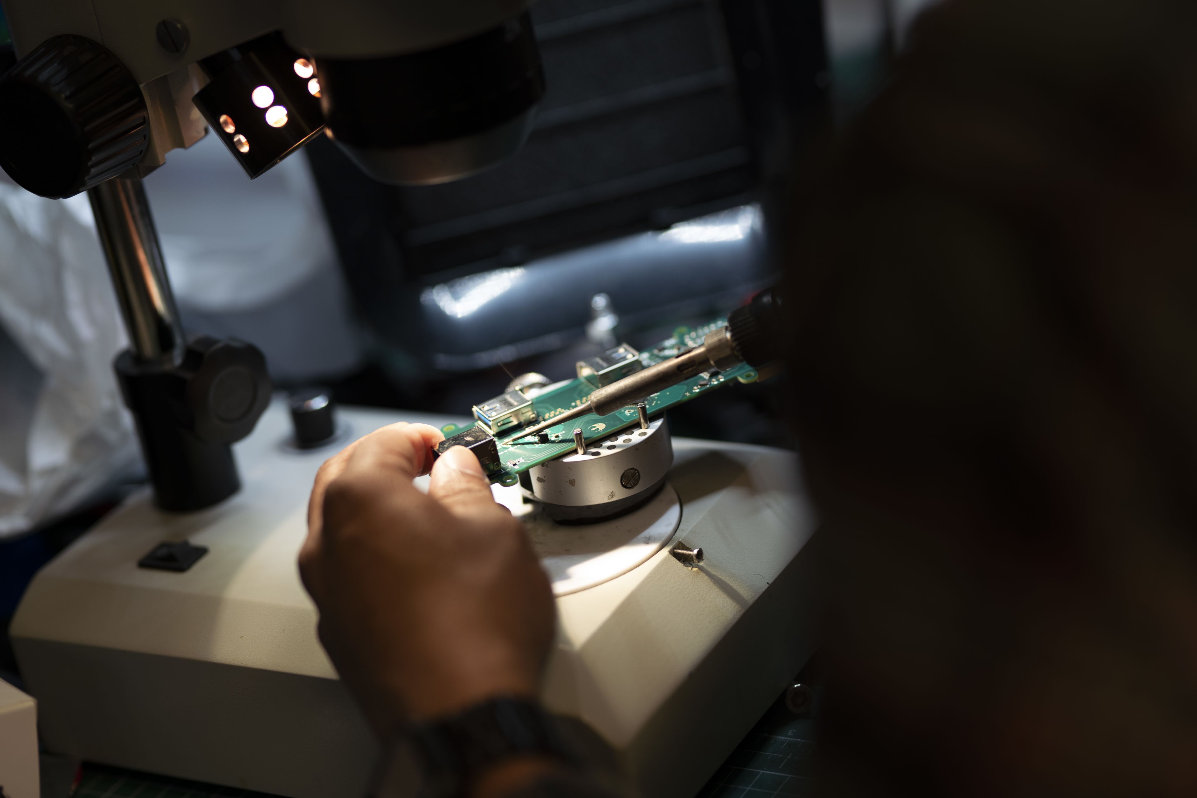 Researcher soldering electrical components onto a chip