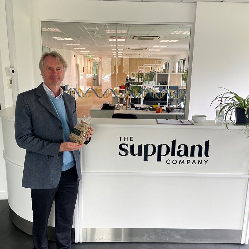 Professor Paul Dupree in The Supplant Company headquarters holding a bag of pasta made with Supplant™ Grain and Stalk Flour.