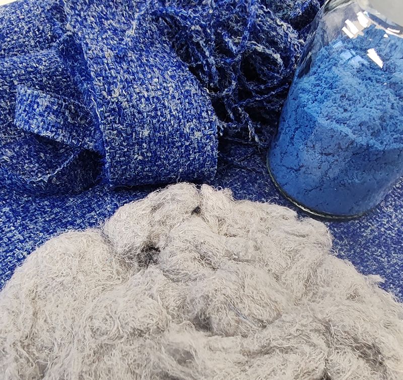 Blue waste fabric alongside recovered fabric fibres and powdered blue dye.