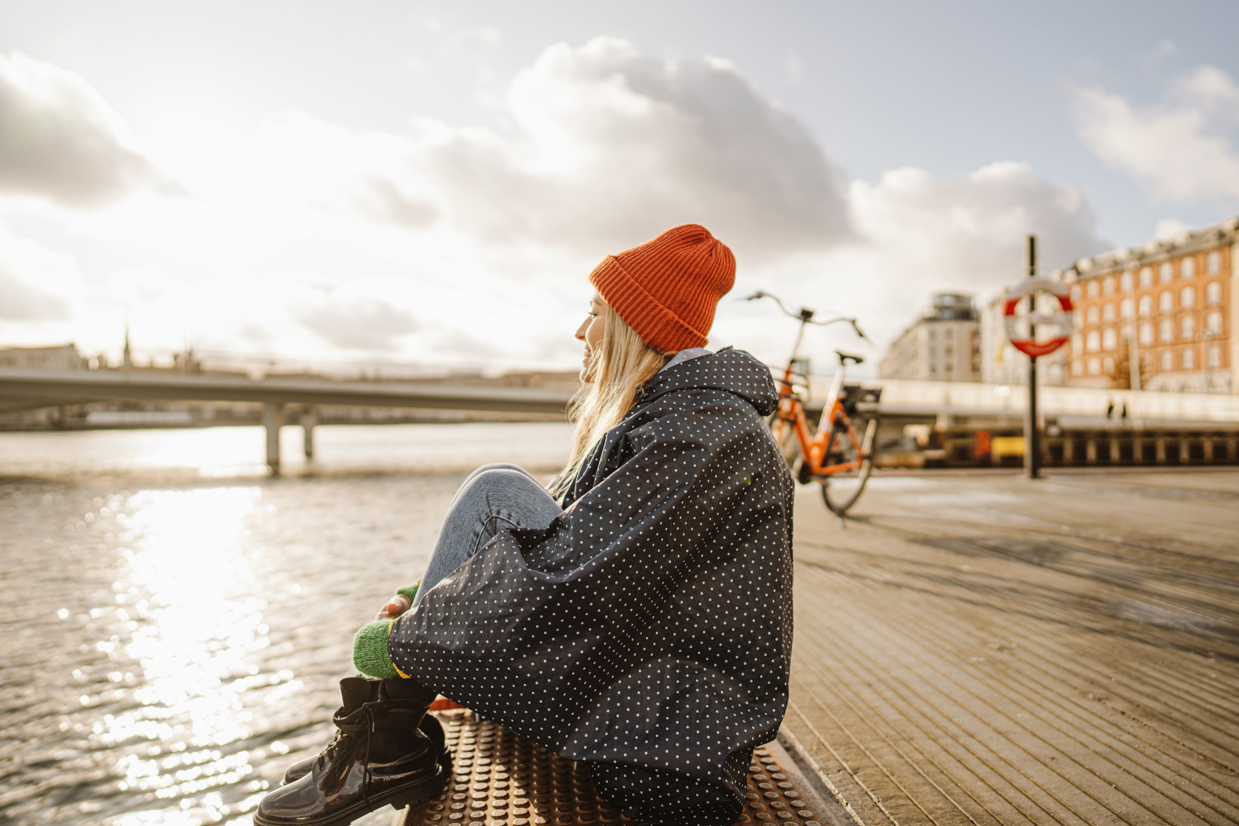 Photo of a woman sitting on the dock; enjoying the view.