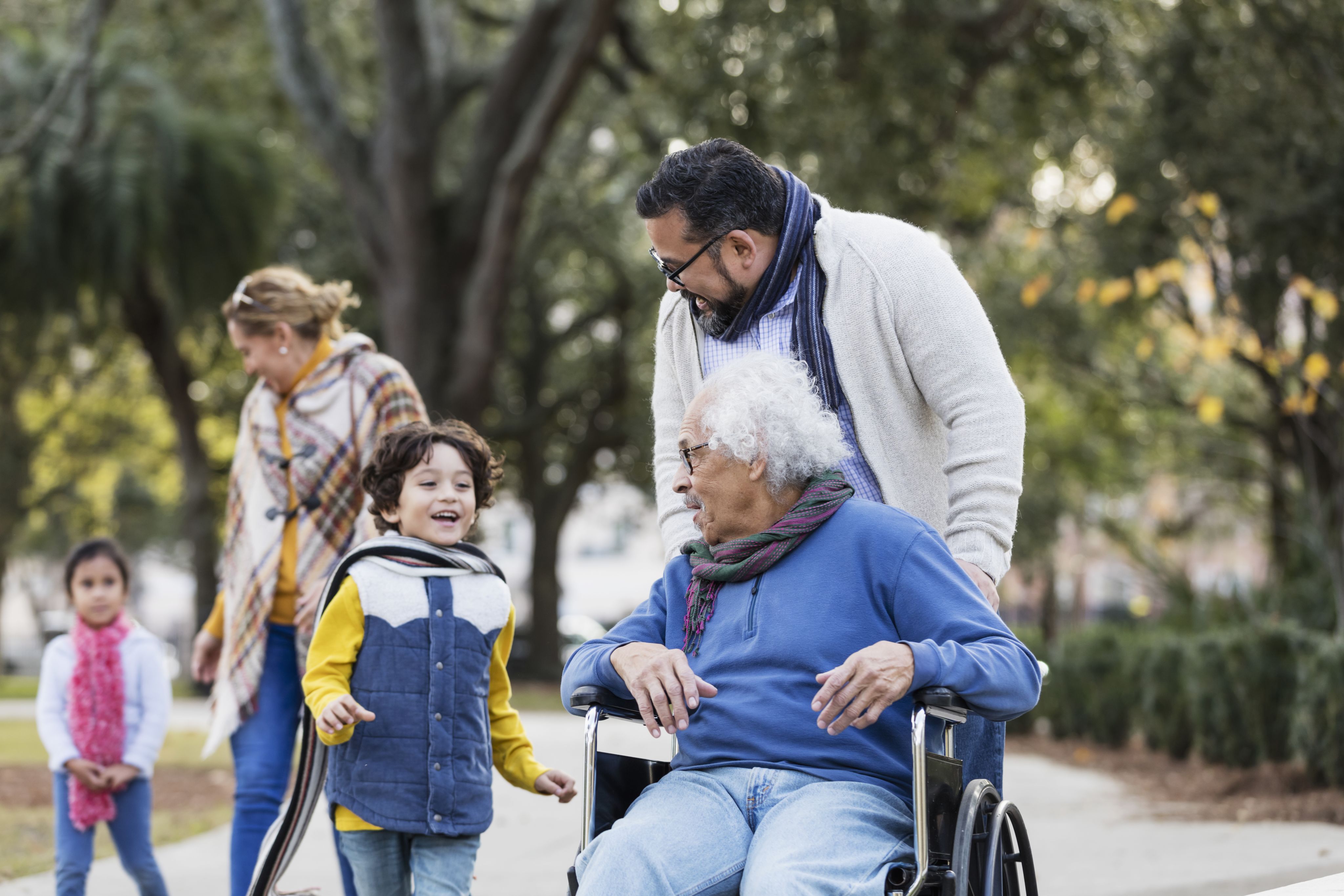 A multi-generation family take a walk together in the park.