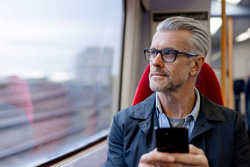 A man stares our of the window while on a train.