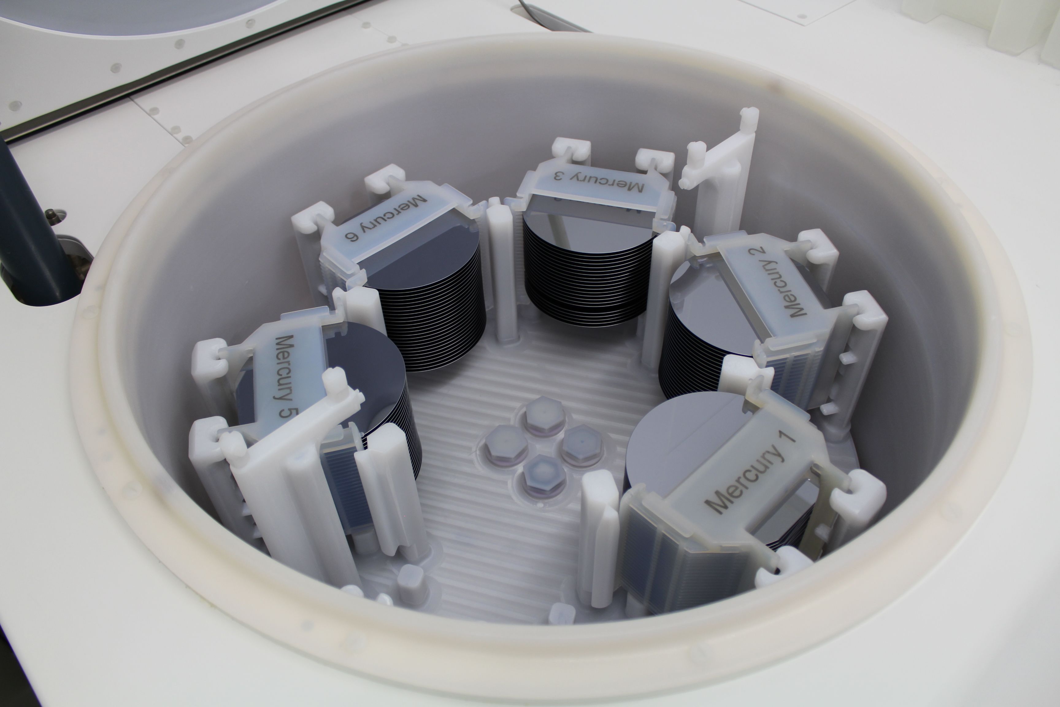 Five individual stacks of mercury sit inside plastic clips holding them in place. The stacks are arranged in a circle sunken into a countertop.
