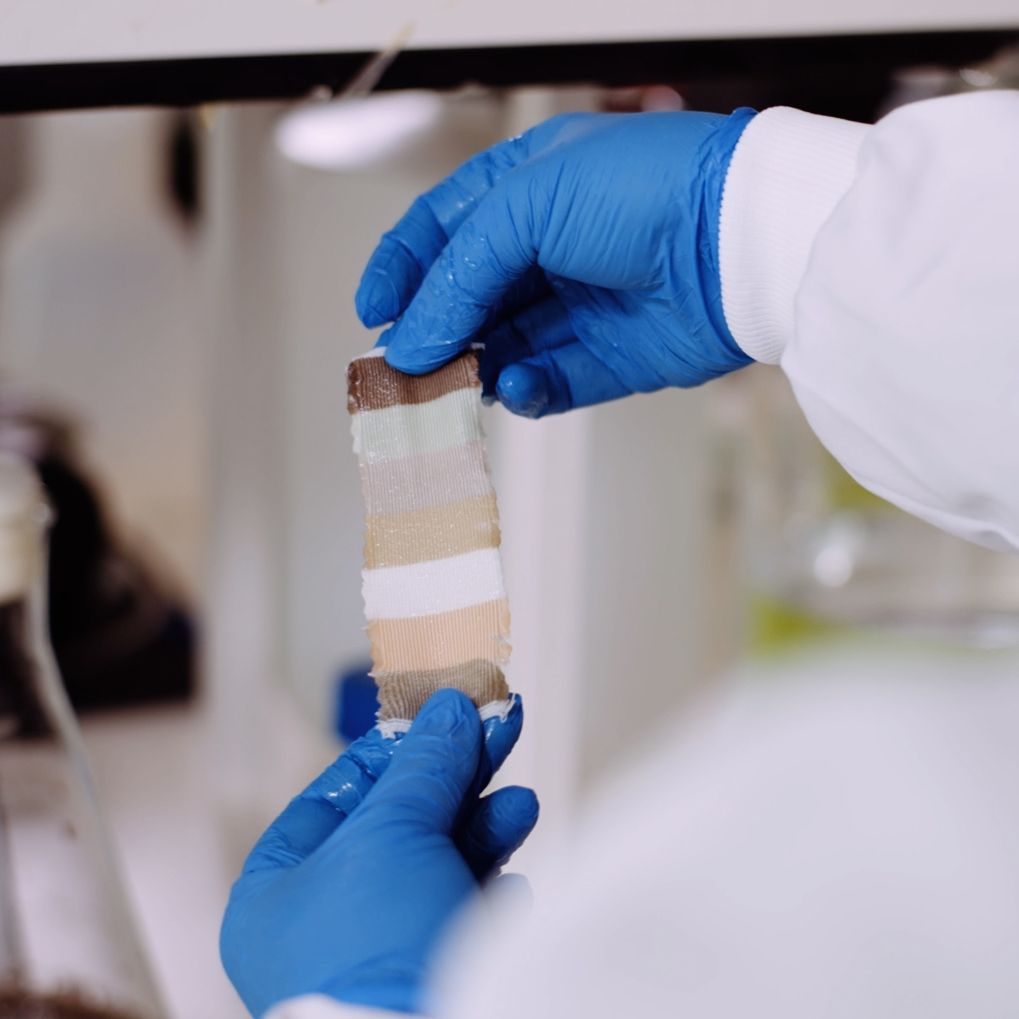 A scientist holding a fabric sample that has been dyed using Colorifix technology