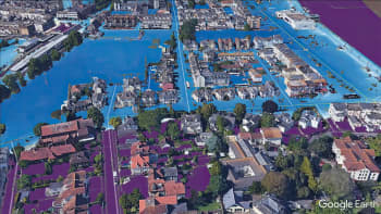An aerial view from googlemaps showing part of a city centre using coloured shading to demonstrate different potential flooding zones