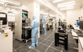 Laboratory workers in protective clothing working in a high tech laboratory enviornment