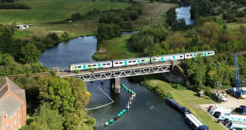 An aerial view of a hydroflex train on a bridge, travelling across a river