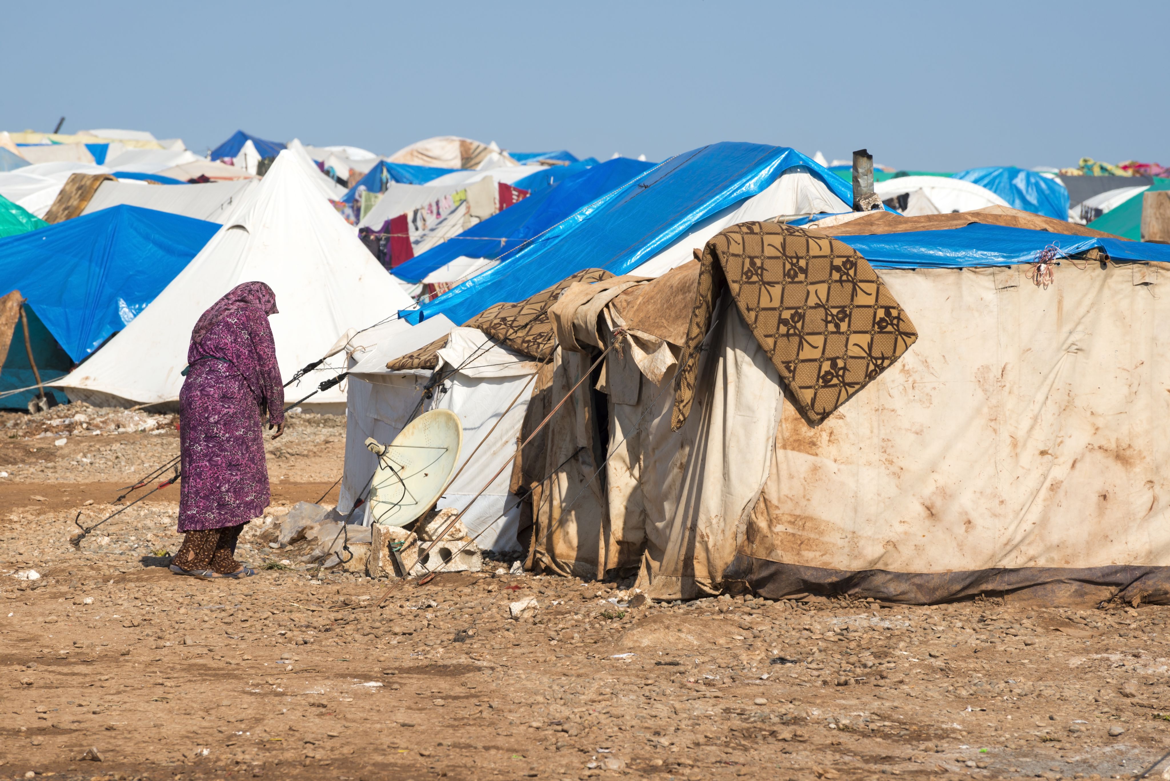 A woman walks through a refugee camp
