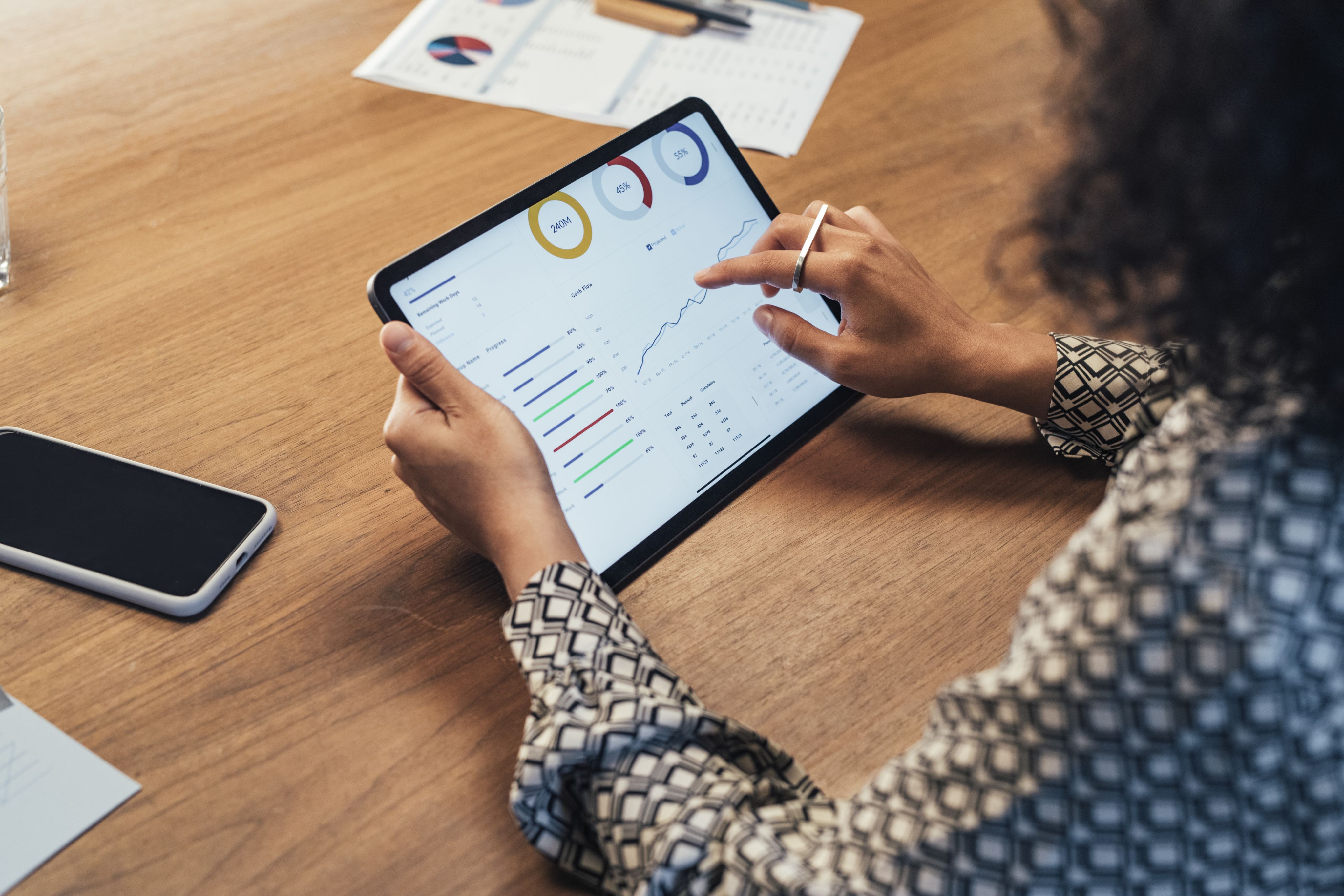 A woman looks at a graph on a tablet