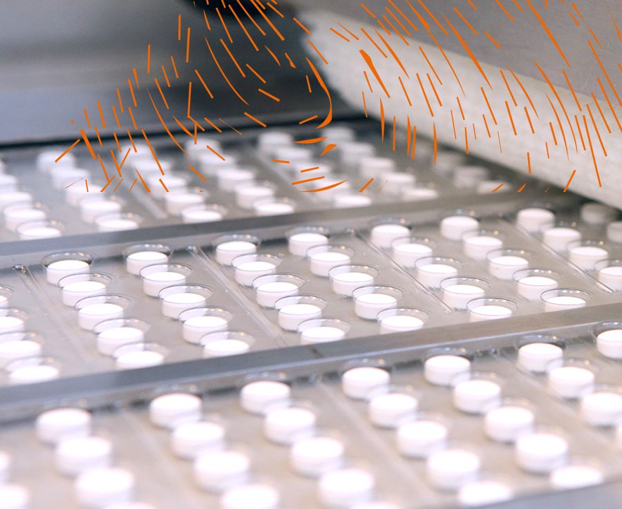 A close up of white tablets in packaging on a production line in a factory