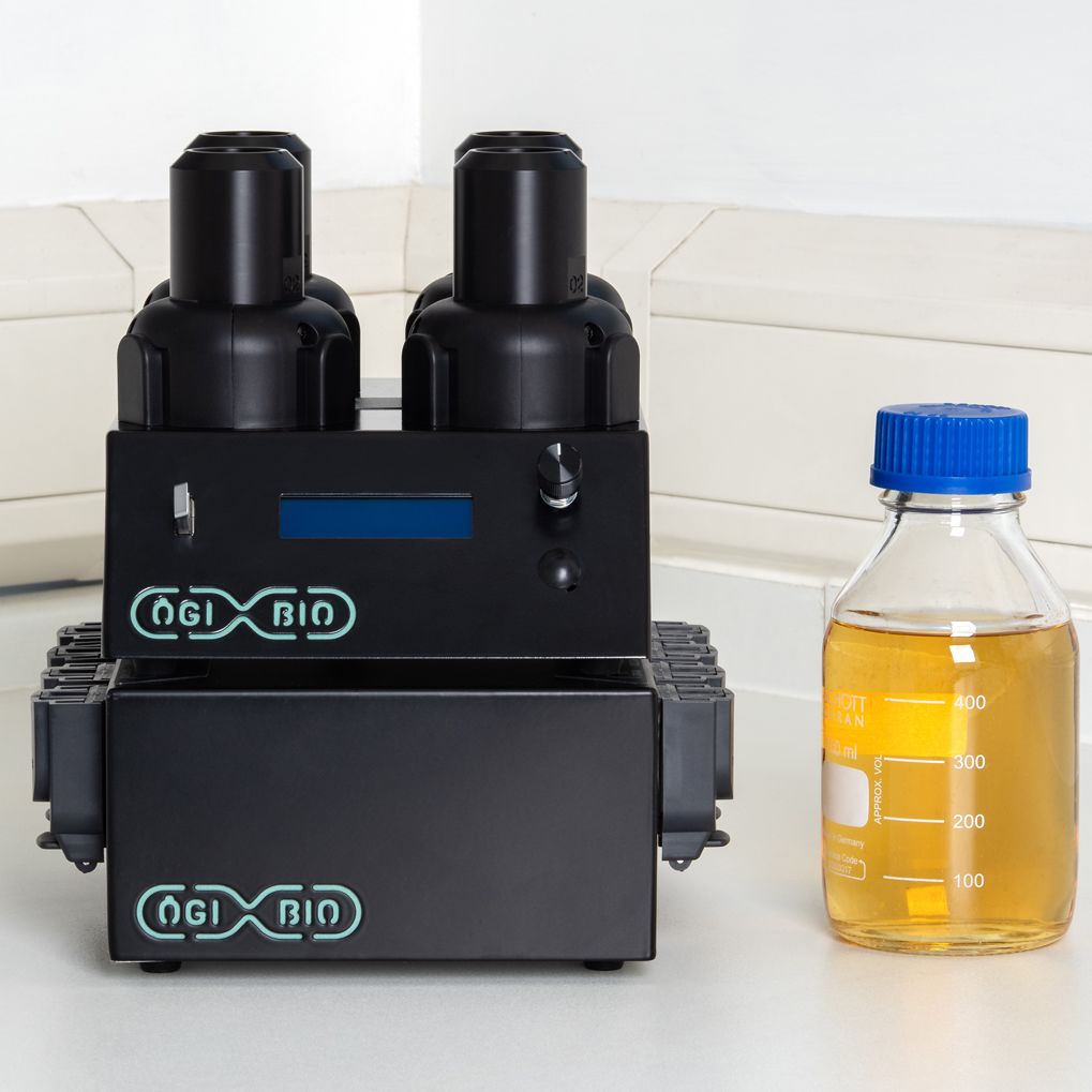 The OGI Bio automated microbial culturing technology next to a bottle of liquid media