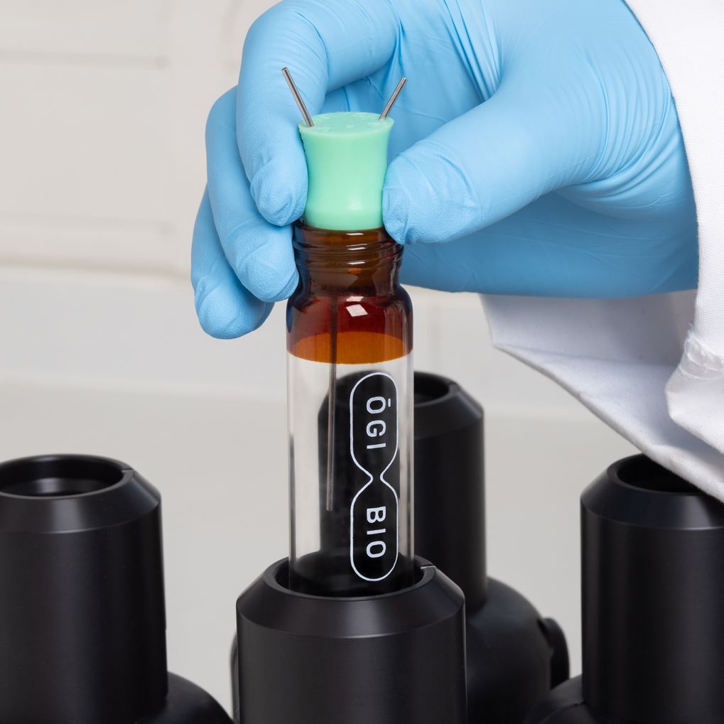 A researcher holding an OGI Bio culture flask